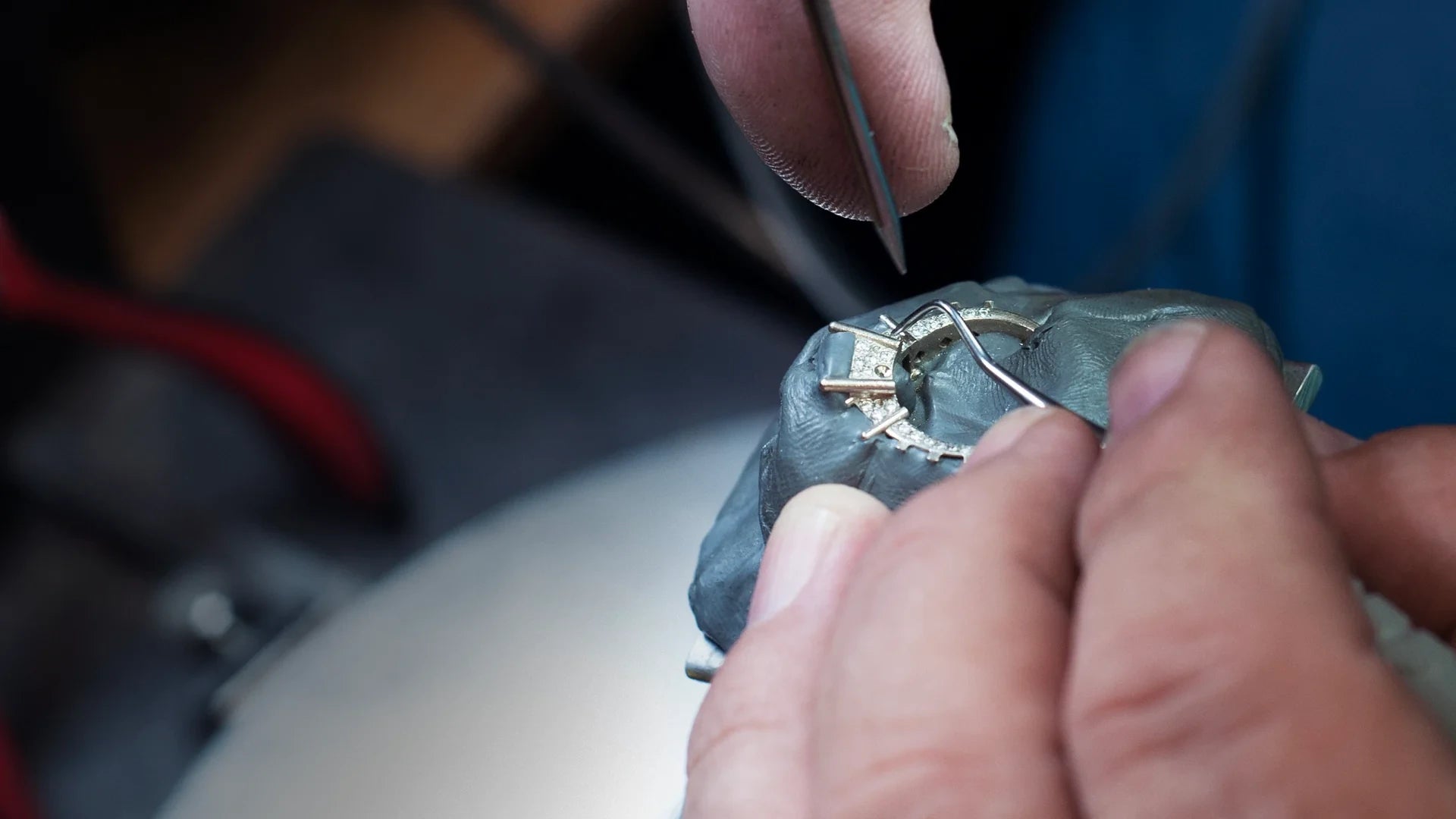Jeweler setting diamonds in a ring.
